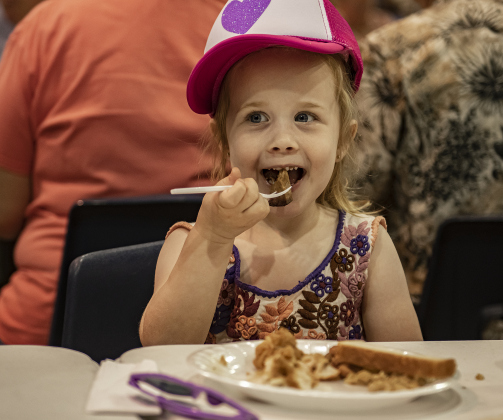 3-year-old Violet Knapek enjoys a bite of brisket.