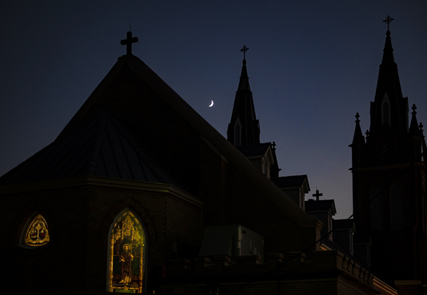 A Waxing Crescent moon, at 22.7% visibility, shines over Holy Trinity Catholic Church of Corn Hill  on Tuesday, September 19, 2023.