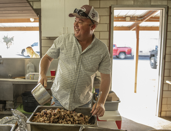 Adam Martinka sorts cubes of brisket in the smoking pit area.