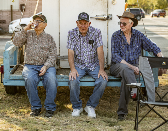 Smoking pit area volunteers Leonard Stojanik, left, John Vrana, center, and Walter Lalla, right, take a rest break from their work.