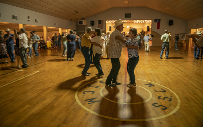 Raymond Knapek (in cowboy hat) dances with Rebecca Ermis in the parish hall.