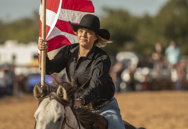 Jenna Anderson carries the American flag through the arena as the National Anthem is played.