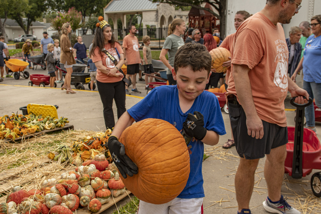7-year-old Andrew Lake gives maximum effort as he unloads  pumpkins.