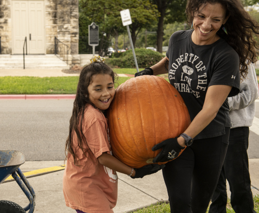 7-year-old Teddi Perez, left, gets help from her mom Jessica Perez as they help  unload  pumpkins at Georgetown's First United Methodist Church on Wednesday, October 11, 2023.