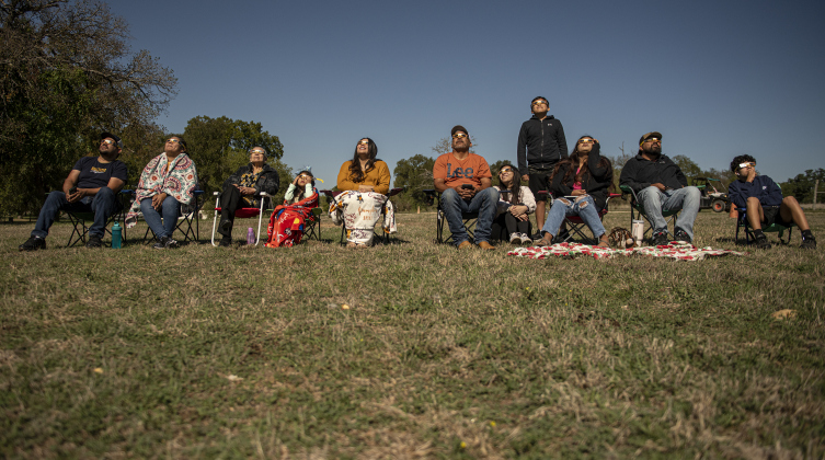 A family gathers to observe the annular eclipse during a Saturday, October 14, 2023 gathering at Berry Springs Parks &amp; Preserve,  hosted by Friends of Berry Springs Park.  An annular eclipse occurs when the moon gets between the earth and sun.  The eclipse's visibility was approximately 89% in the Austin area.