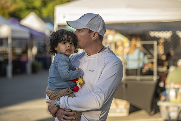 J.T. Boone snuggles with his 19-month-old son River as they wait for mom, who was looking for shopping bargains.