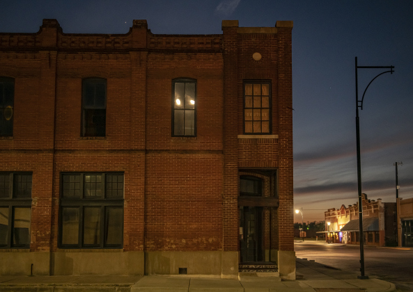 A Waxing Gibbous moon, at 97.1% visibility, is reflected twice in the upper floor windows of a building along West  Clark Street in downtown Bartlett on Wednesday evening, September 27, 2023.