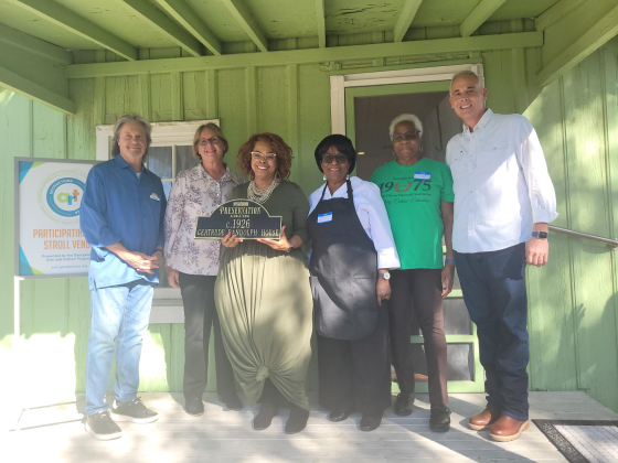 Regina Durden, center, holds the “Gertrude Randolph House” plaque after Preservation Georgetown presented it to the Georgetown Cultural Citizens Memorial Association.