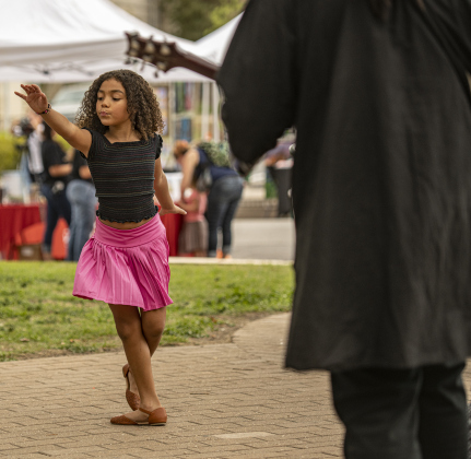 7-year-old Lyric Elegonye dances to the music of Mega'Tune during the South Main Arts Festival on Saturday, October 21, 2023.  Her father is group member Tyrell Elegonye, pictured on guitar at right.