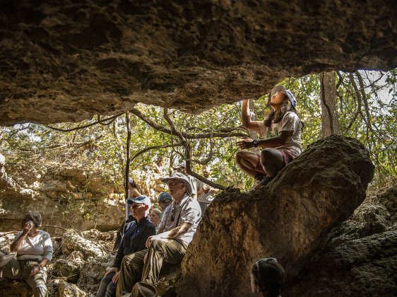 Jason Rodriguez looks over features of a limestone cave (one of several) at Pecan Springs Karst Preserve.