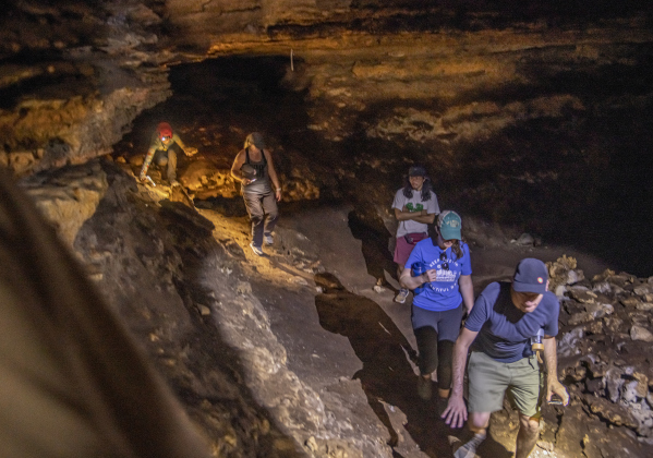 Attendees explore a limestone cave  at Pecan Springs Karst Preserve on Saturday, September 23, 2023.