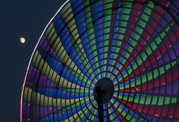 A Waxing Gibbous moon, at 89.9% visibility, shines over a Ferris wheel midway ride  on Wednesday night,  October 25, 2023, the opening day of the Williamson County Fair and Rodeo, held at the Williamson County Expo Center through October 28th.