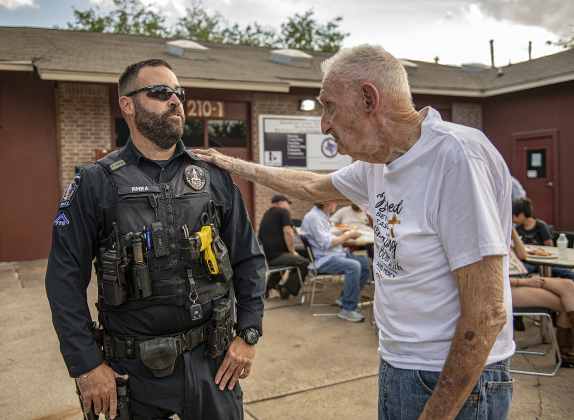 Georgetown police officer Keith Rhea takes time to visit with 88-year-old Orville Ramsey, right, during a National Night Out event held at Stonehaven Apartments.