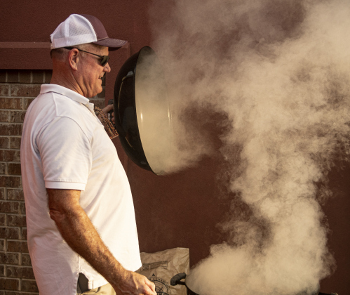 Jeff Brennan grills burgers and hot dogs  during a National Night Out event held at Stonehaven Apartments. Brennan's wife Nikki is the Stonehaven Apartments Executive Director.