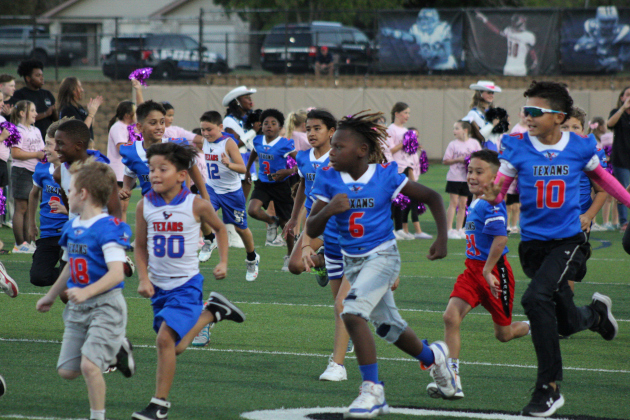 Kids from Carver Elementary run across the field before the game starts. Photo by Nalani Nuylan.