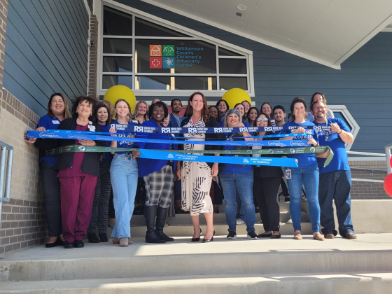 Williamson County Child Advocacy Center Chief Executive Officer Kerrie Stannell, center, stands with the center’s staff before they cut the ribbons at the grand opening on Friday November 3. 