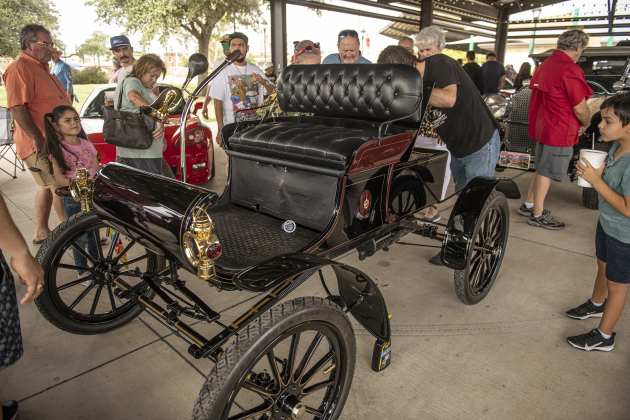 Attendees look at a 1903 Oldsmobile owned by Tom Roland of Pflugerville during Taylor's Main Street Car Show on Saturday, October 28, 2023.