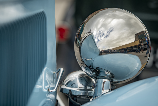 One of the chrome headlamps on a 1934 Ford Cabriolet owned by James Kincheloe reflects a portion of Main Street during Taylor's Main Street Car Show on Saturday, October 28, 2023.