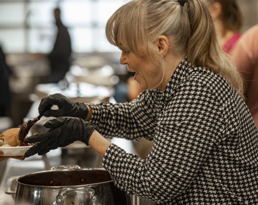 Linda Porter helps dish up meals in the serving line  at  the Community Thanksgiving, held at the Georgetown Community Center in San Gabriel Park on Thursday, November 23, 2023.