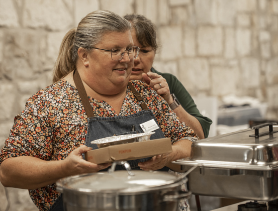 Alycia Tandy, front, and Johnnie Kovar, right, help with meal preparation during  the Community Thanksgiving, held at the Georgetown Community Center in San Gabriel Park on Thursday, November 23, 2023. Tandy is the founder of Community Thanksgiving.   Everyone was welcome for a sit-down meal at the center, with volunteers also delivering meals to area homes.