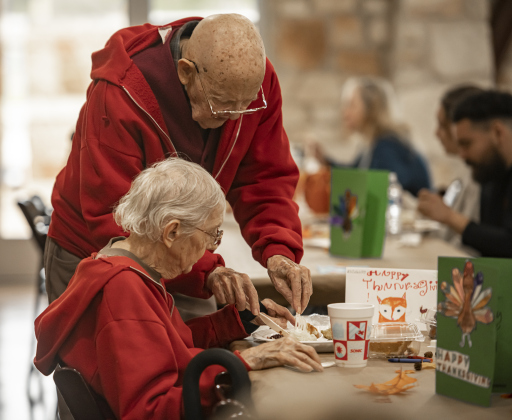 90-year-old Jerry Ayers helps his wife Joan, 91, with preparing her food to eat during the Community Thanksgiving, held at the Georgetown Community Center in San Gabriel Park on Thursday, November 23, 2023. The couple has been married 65 years.
