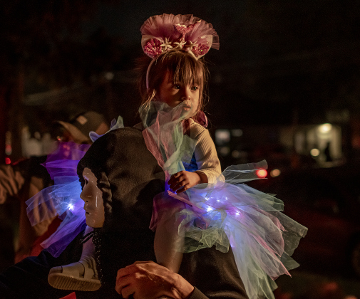 2-year-old Savannah Gonzalez sits on the shoulders of her uncle David Ruiz as they enjoy Halloween night  along Main Street in Old Town on Tuesday, October 31, 2023.