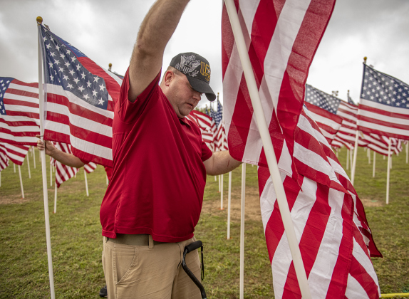 Erik Stoeckle helps place flags  at the Field of Honor on Saturday, November 4, 2023.