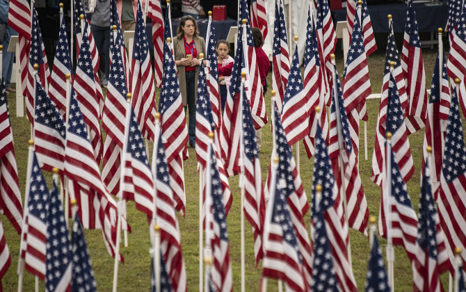 Kelli Aviña and her daughter Lourdes, 8, are surrounded by  American flags at the Field of Honor on Saturday, November 4, 2023.
