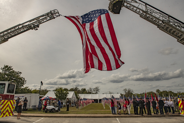 A large American flag provided by the Georgetown Fire Department flies over the Field of Honor site during the event's opening ceremonies on Sunday, November 5, 2023.