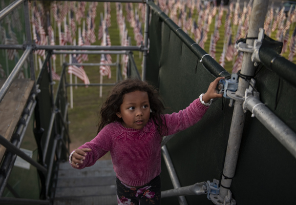 4-year-old Milove Helgerson climbs the stairs to the viewing area for  American flags that  adorn a field behind the Hammerlun Center for Leadership and Learning on Friday, November 3, 2023, the evening before the official opening of the 7th Annual Field of Honor.