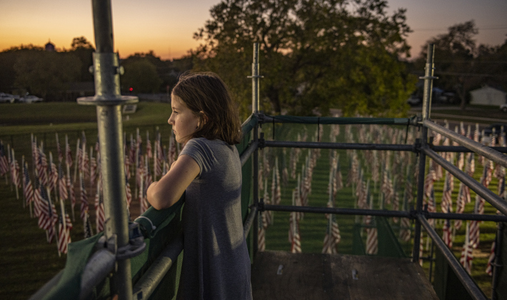 From an elevated viewing area,  9-year-old River Mortensen admires American flags  covering  a field behind the Hammerlun Center for Leadership and Learning on Friday, November 3, 2023, the evening before the official opening of the 7th Annual Field of Honor.