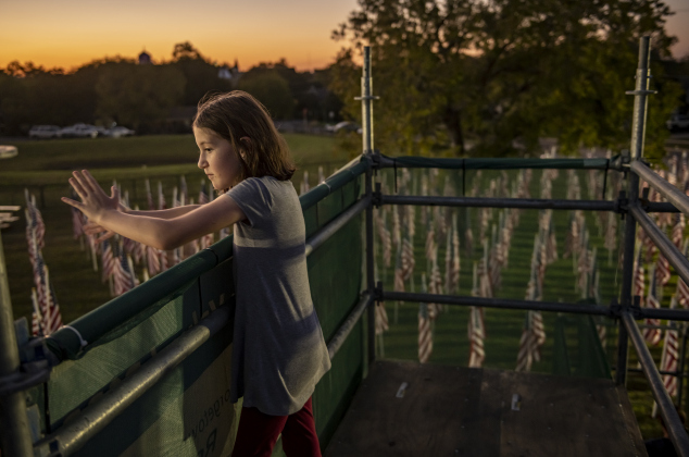 From an elevated viewing area,  9-year-old River Mortensen admires American flags  covering  a field behind the Hammerlun Center for Leadership and Learning on Friday, November 3, 2023, the evening before the official opening of the 7th Annual Field of Honor.