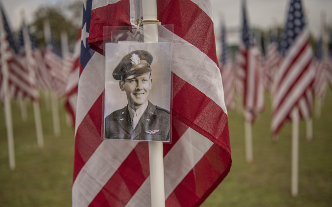 A photograph of World War II Army Air Corps member Ed Olson, who died in 2018, was placed on a flag honoring him by his son Larry Olson  at the Field of Honor on Saturday, November 4, 2023.  Ed Olson was with the 384th Bombardment Group.