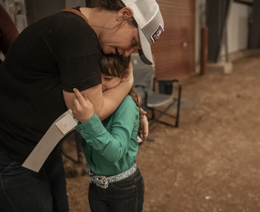 8-year-old Reagan Erickson of Georgetown, a member of the Williamson County 4-H Club, gets a hug from her mom Tara Erickson after winning a third-place ribbon with her pig named Dottie  after taking part in her first ever livestock show competition during the Williamson County Livestock Show on Tuesday, December 5, 2023.