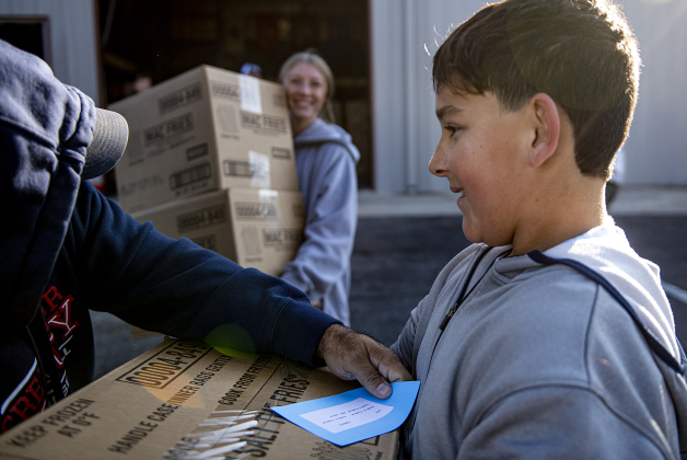 11-year-old Anthony Gomez, front, and 15-year-old Kamryn Stone, in back, were among the volunteers helping distribute gift boxes  during the Georgetown Police Department's Blue Santa distribution, held Saturday, December 16, 2023.