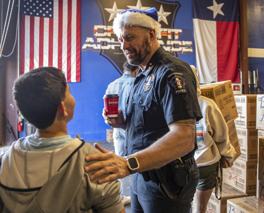 Police Chief Cory Tchida shows his appreciation to volunteer helper Anthony Gomez, 11, during the Georgetown Police Department's Blue Santa distribution, held Saturday, December 16, 2023 at the Georgetown Public Safety Headquarters.