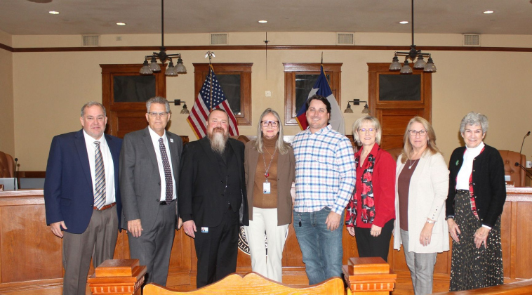 Peggy Vasquez, center, stands with the Williamson County Commissioners and County Attorney Dee Hodds, left, after working for the county for 31 years. Photo courtesy of Williamson County.