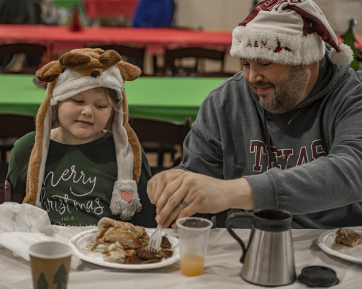 7-year-old Addie Medema gets assistance from her father Ryan Medema.