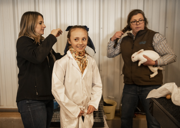 11-year-old Emily Miller, center, a member of the Florence F.F.A., gets help with her hair and clothes from her teacher Jacqueline Donathan, left, while Emily's mom Kelli Miller, right, holds one of her rabbits during the Market Rabbit Show at the Williamson Livestock Show  on Sunday, December 3, 2023.  The annual event is held at the Williamson County Expo Center.