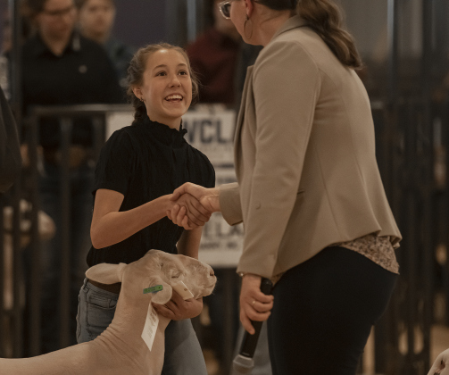12-year-old Audy Morgan, a student at Georgetown's Wagner Middle School, is pictured with her lamb named Winter as she is congratulated by Market Lamb category judge Sierra Nauman  at the Williamson County Livestock Show  on Monday, December 4, 2023.