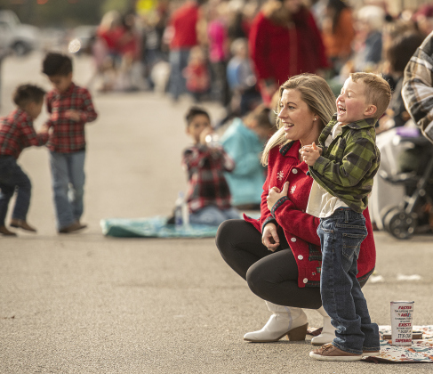 Calvin Hill, 4, enjoys festivities with his mom Kate Hill along Austin Avenue as they wait for the parade to begin.