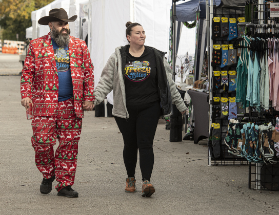 Donny Severson, dressed in brightly-colored holiday attire, was joined by his wife Nicole as they walked along the Main Street vendors.