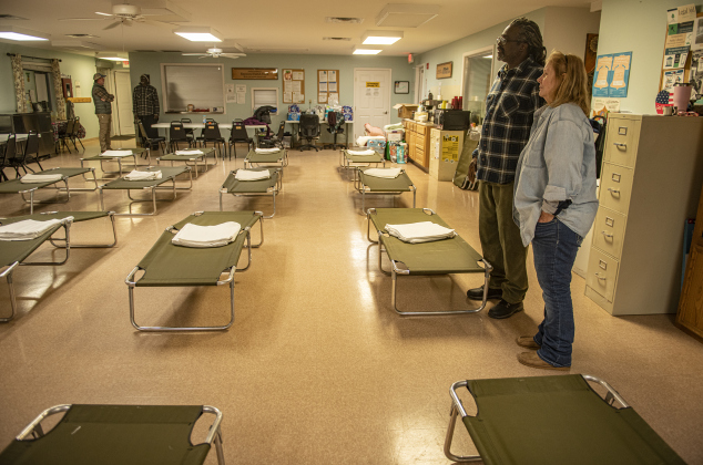 Nate Bonner, with Helping Hands of Georgetown, looks over cots with Lisa Pierce  on Sunday, January 14 at the Madella Hilliard Neighborhood Center. Pierce, a volunteer with Helping Hands of Georgetown, is also homeless, living in her truck.