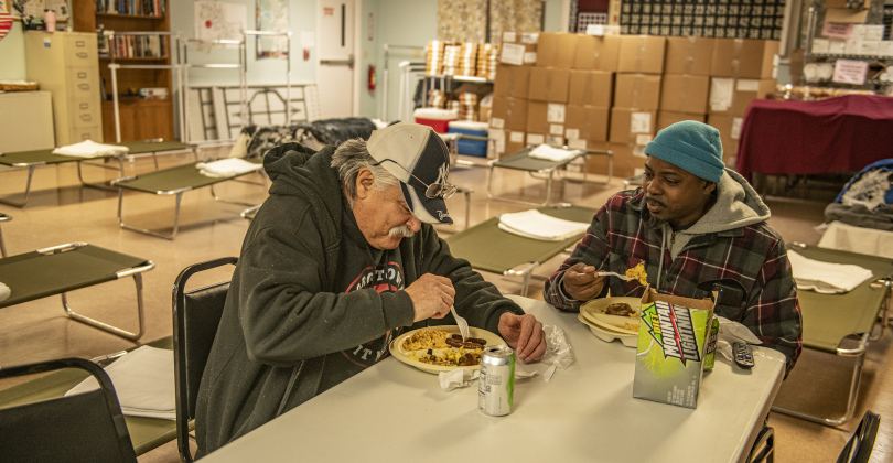 Henry Correa, Jr., left, and Nick Kendricks, right, enjoy a hot meal on Sunday, January 14 at the Madella Hilliard Neighborhood Center. Photo by Andy Sharp.