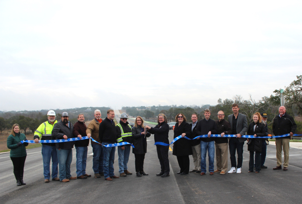 Celebrating the completion of County Road 258 are, from left, Ragan Riggs, Bruce Thurin, Steven Shull, Steven Widacki, John Nichols, Liberty Hill ISD Superintendent Steve Snell, Precinct 2 Commissioner Cynthia Long, Kathy Major, Christen Eschberger, Chase Myers, Eddie Church, Randy Ehresman, Adam Pfeiffer, Heather Sulaica, Estes Major, and Joe Bland. Photo courtesy of Williamson County.