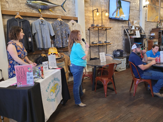 Executive Director for Faith in Action Lisa Hill, center, welcomes the crowd at Mesquite Creek Outfitters to their Name That Tune Bingo hosted by Texas Red Entertainment. 