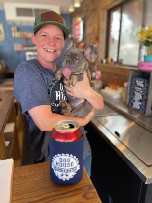 Jodie Hooks, owner of Dog House Drinkery &amp; Dog Park, stands with a happy customer. Photos courtesy Dog House Drinkery &amp; Dog Park