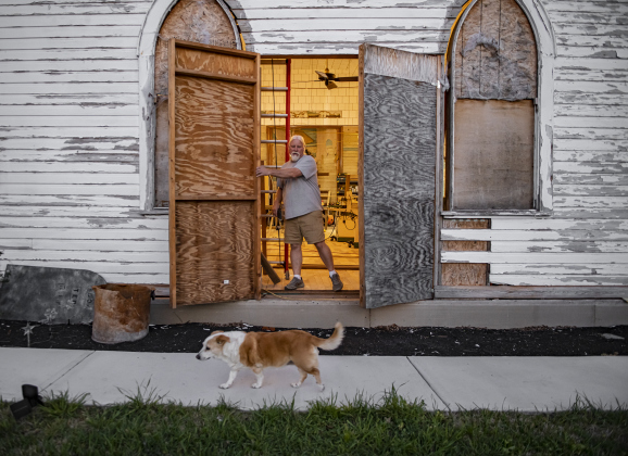 Robert Halstrom, joined by his dog Ladybug, prepares to shut down work for the night  at the former Granger First United Methodist Church.