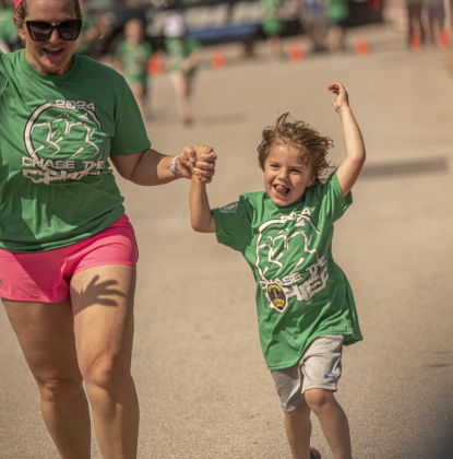 Ashley Doblado and her son Cruz, 4, join hands as they prepare to cross the finish line in  the Fun Run.