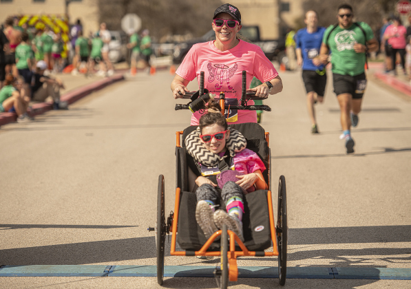 Ainsley's Angels team member  Brooke Crosby is assisted  by Betsy Post  as they participate in the 5K race.